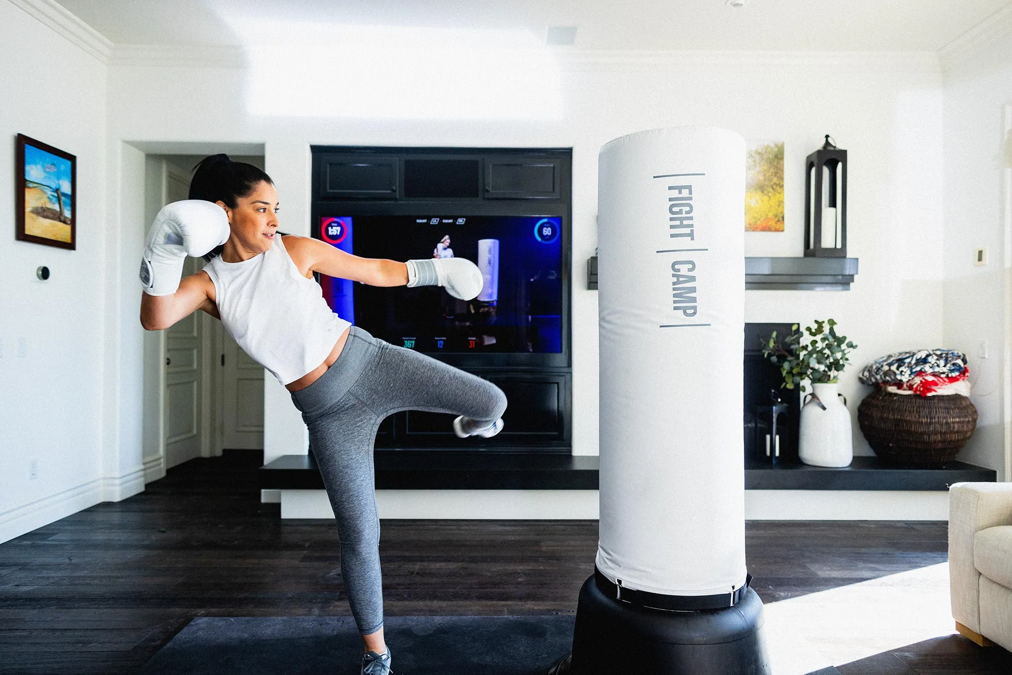 Woman taking FightCamp kickboxing on-demand class in her living room